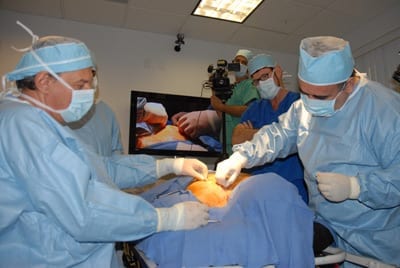 breast-lift-being-done-by-drs-serdev-and-nader-with-dr.-john-cobb-looking-on