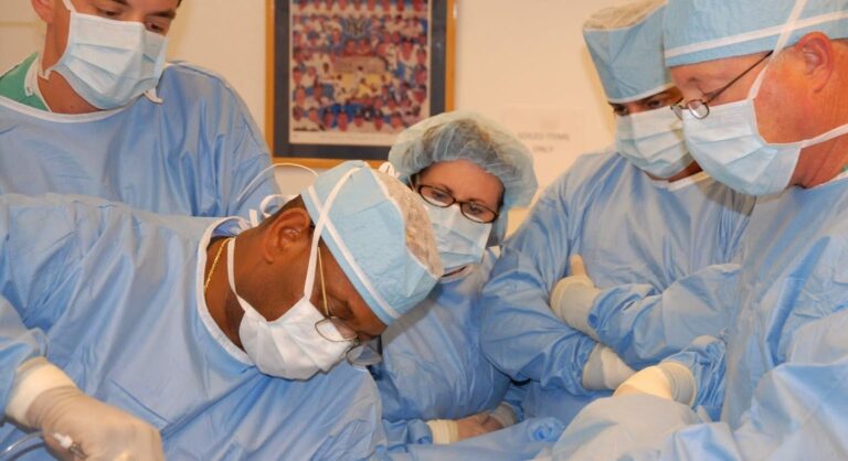 Dr. Reynolds demonstrates correct liposuction technique on his patient to trainees at his office in Coral Springs, Florida.