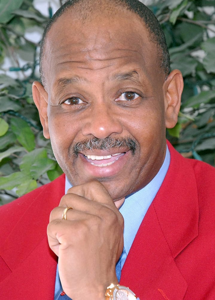 Headshot of Dr. Dwight C. Reynolds, MD in red blazer.